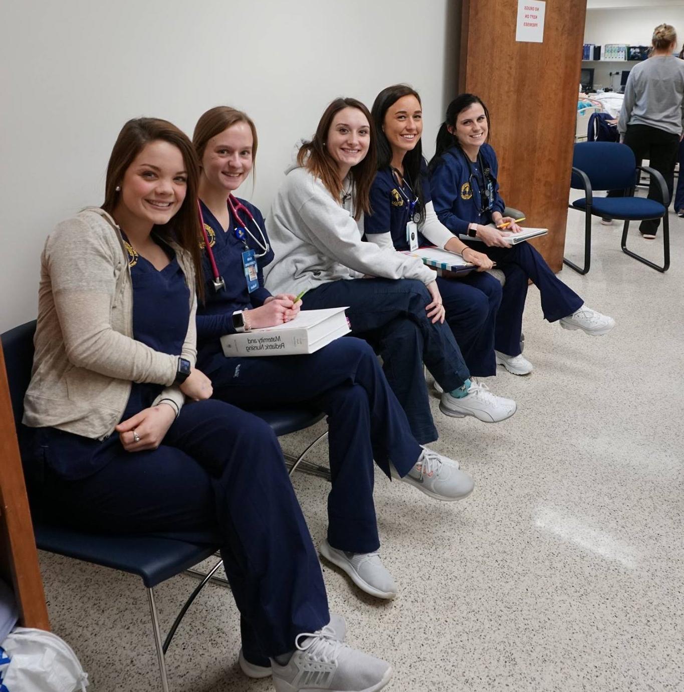 Young nursing students are sitting in chairs waiting their turn