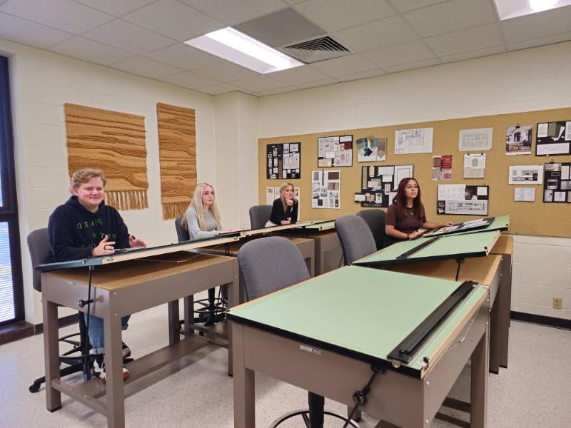 Student working on science projects seated at table.