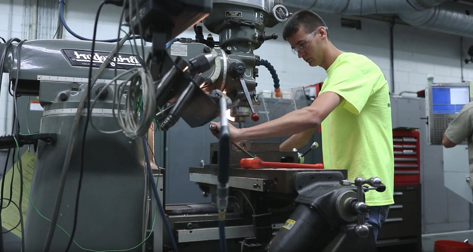 A student works with the manufacturing press in the lab